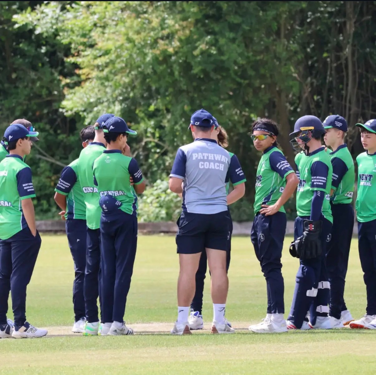 Ciaran leading a group discussion with junior cricketers on the cricket field.
